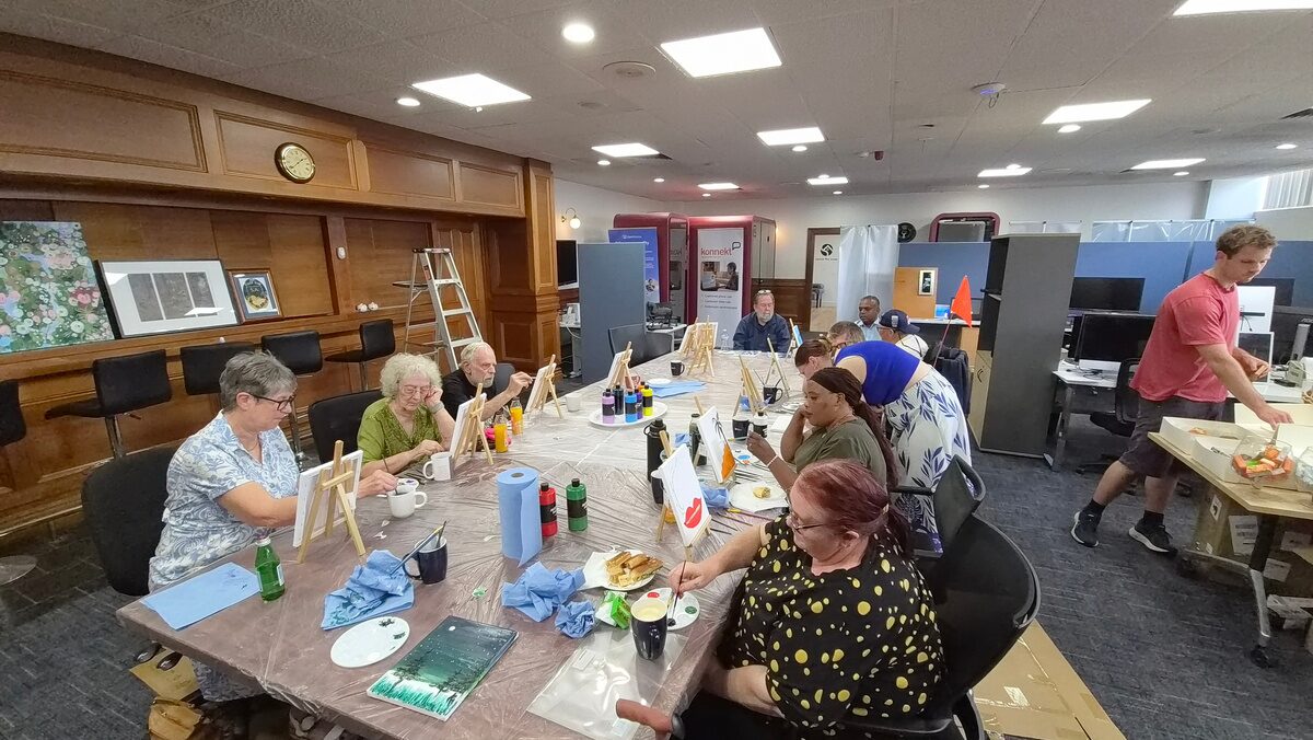 Clients and staff painting together at the Police HomeCare Paint and Sip day